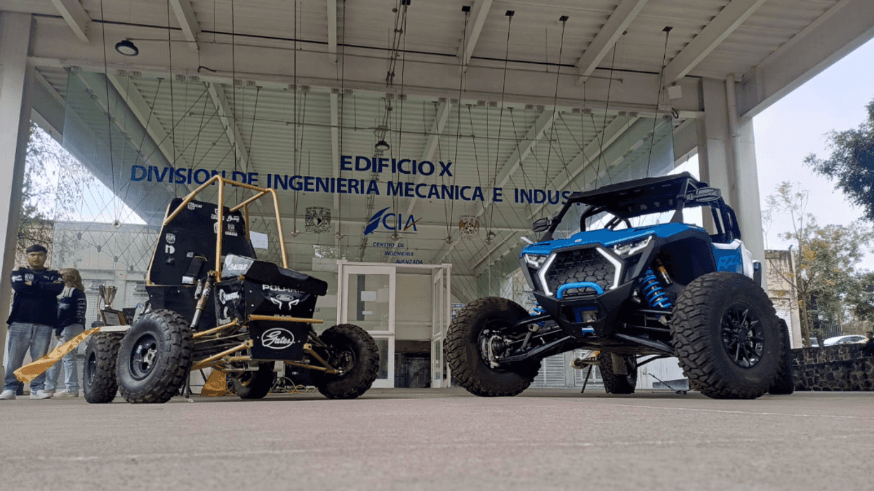Two off-road vehicles displayed outside an engineering building.