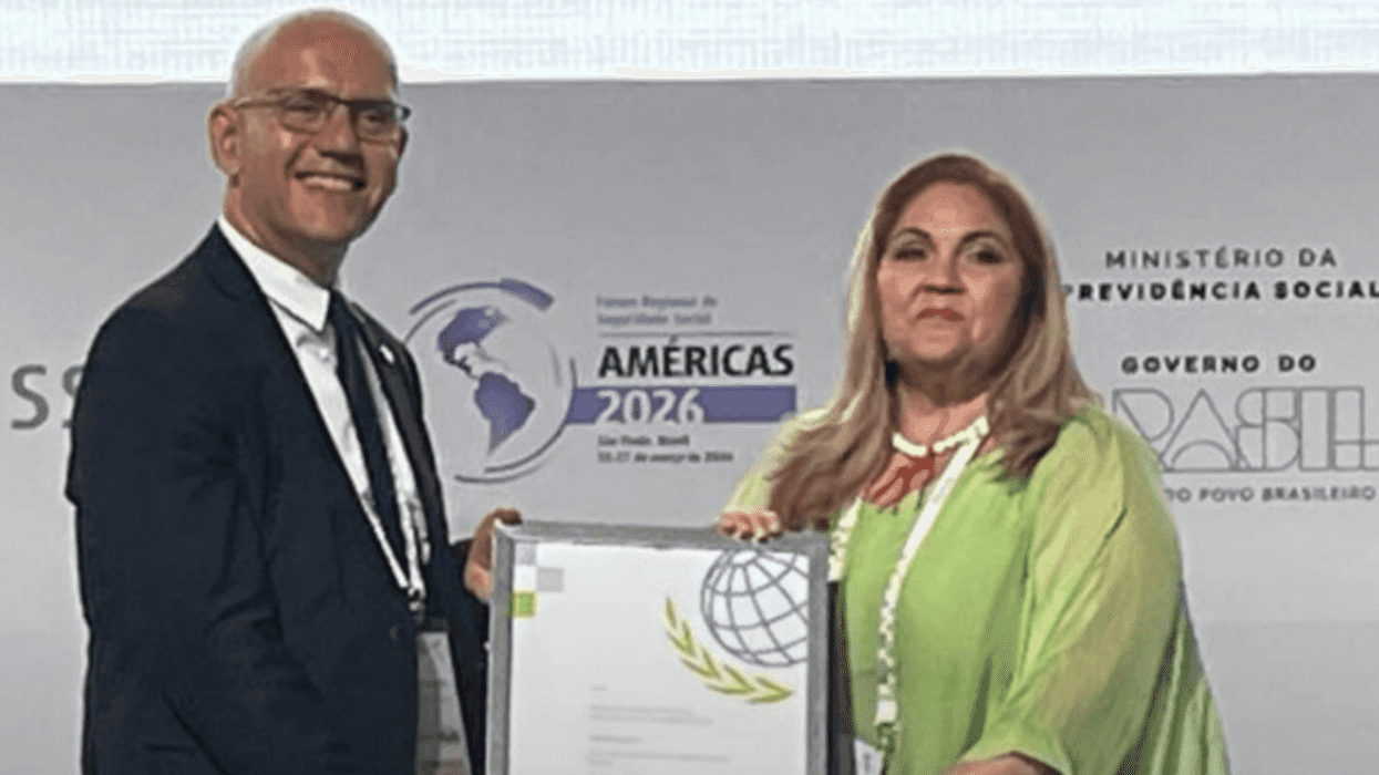 Two people holding a certificate at a formal event.