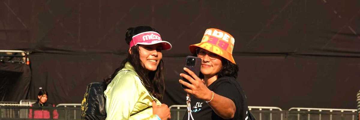 Two people taking a selfie at Vive Latino festival entrance.