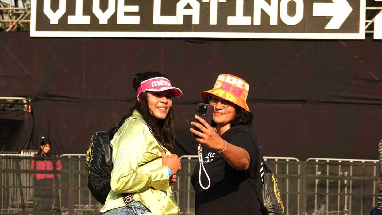 Two people taking a selfie at Vive Latino festival entrance.