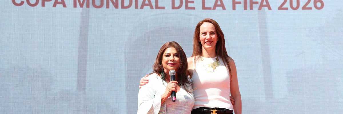 Two women stand on stage at the FIFA World Cup 2026 trophy tour event.