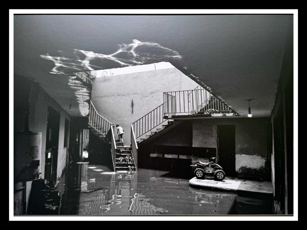 Un ni\u00f1o sube al segundo piso de una vivienda parcialmente inundada.