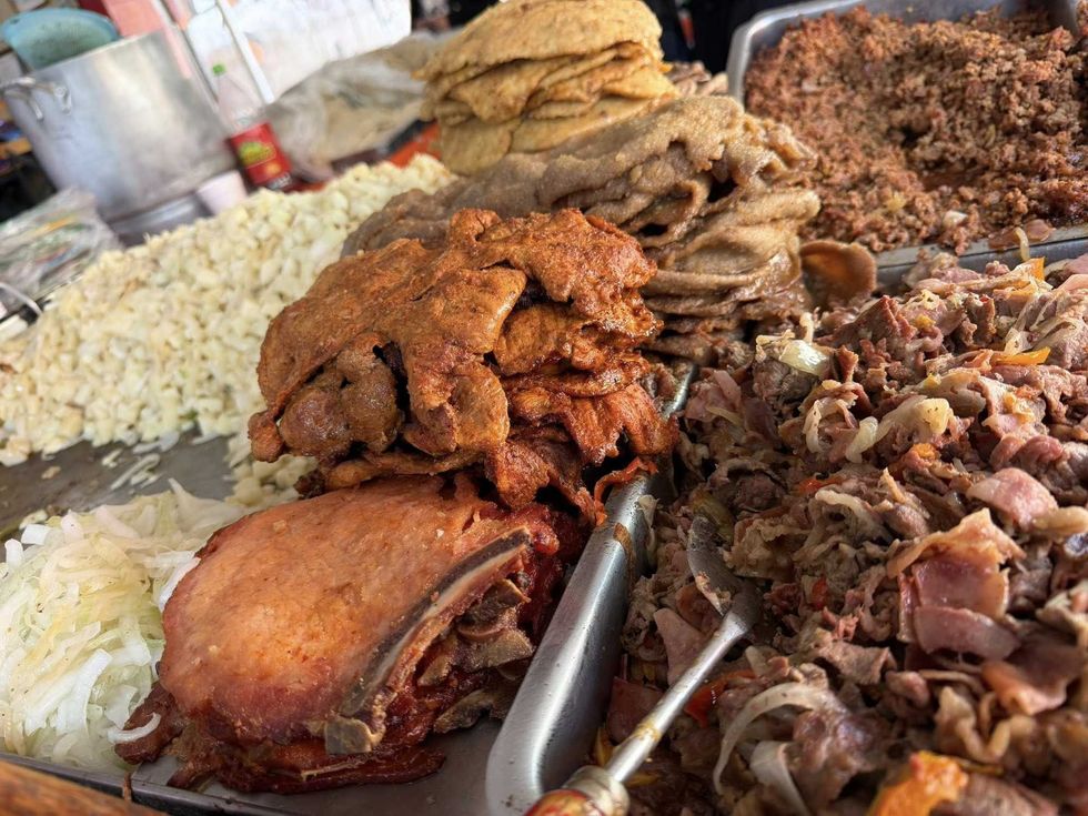 Variety of meats and tortillas on display, including chopped and grilled pieces.