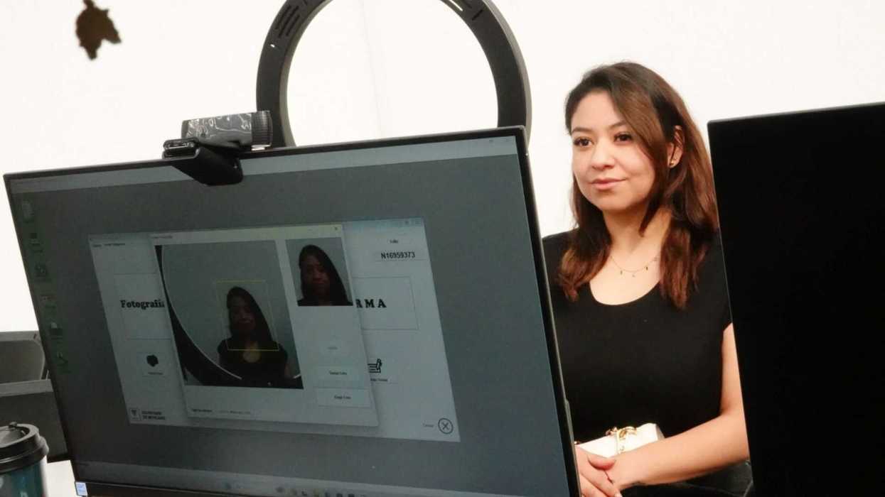 Woman sitting behind a computer with a webcam, her image is on the monitor.