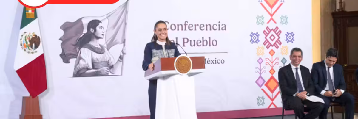 Woman speaking at a podium during a live broadcast in Mexico, with officials seated nearby.