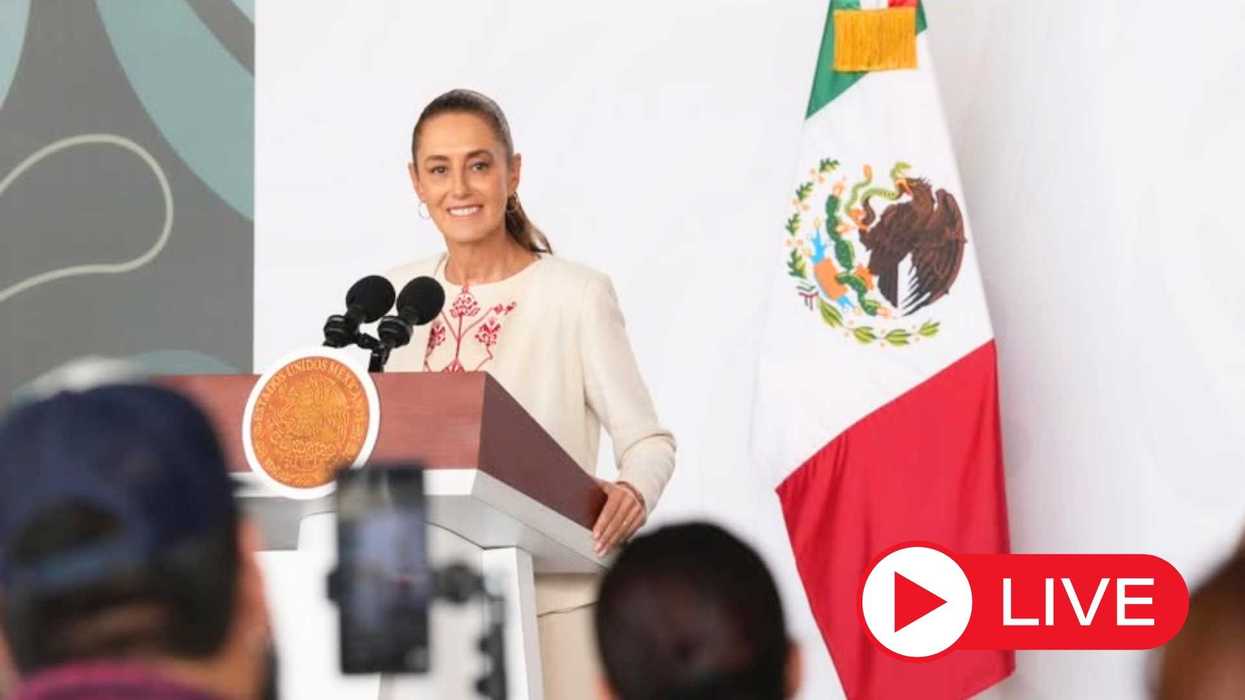 Woman speaking at a podium with a Mexican flag, live event indication.