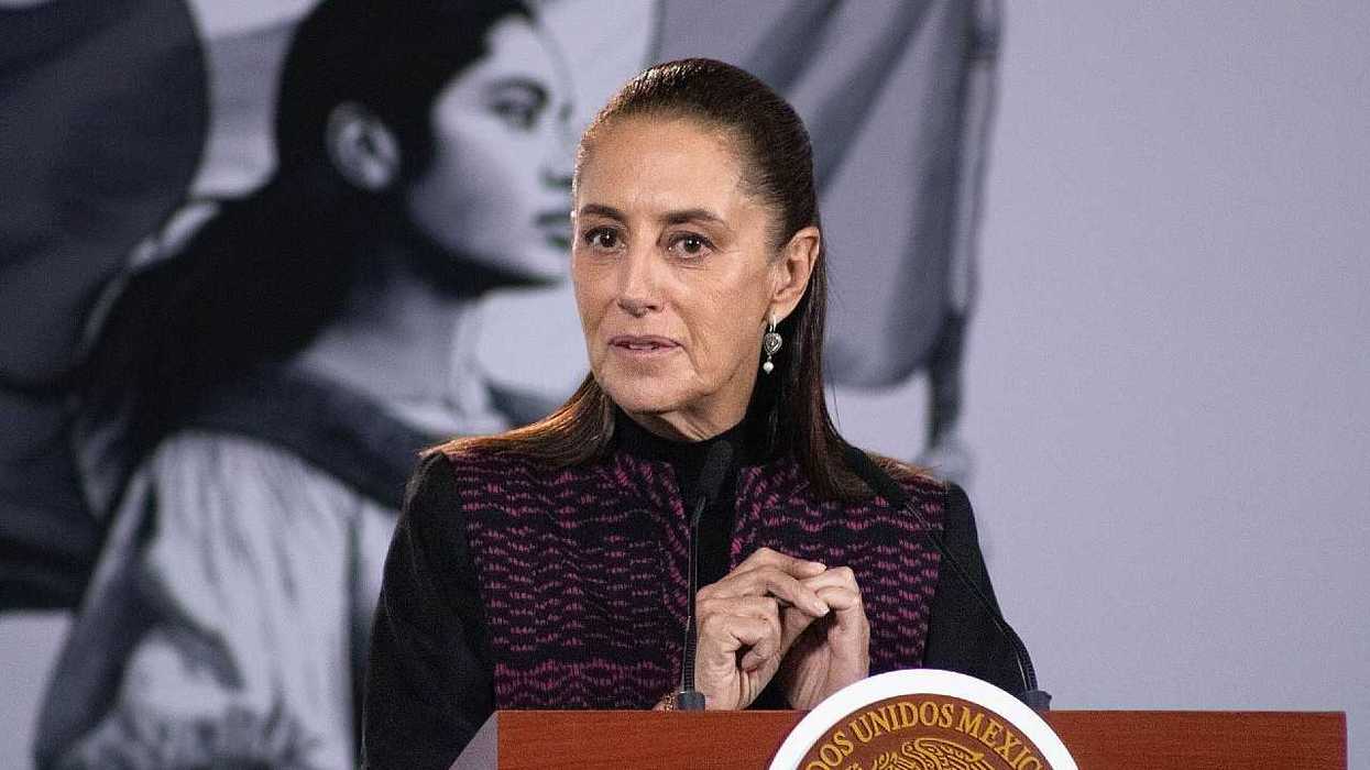 Woman speaking at podium, black-and-white portrait in the background.