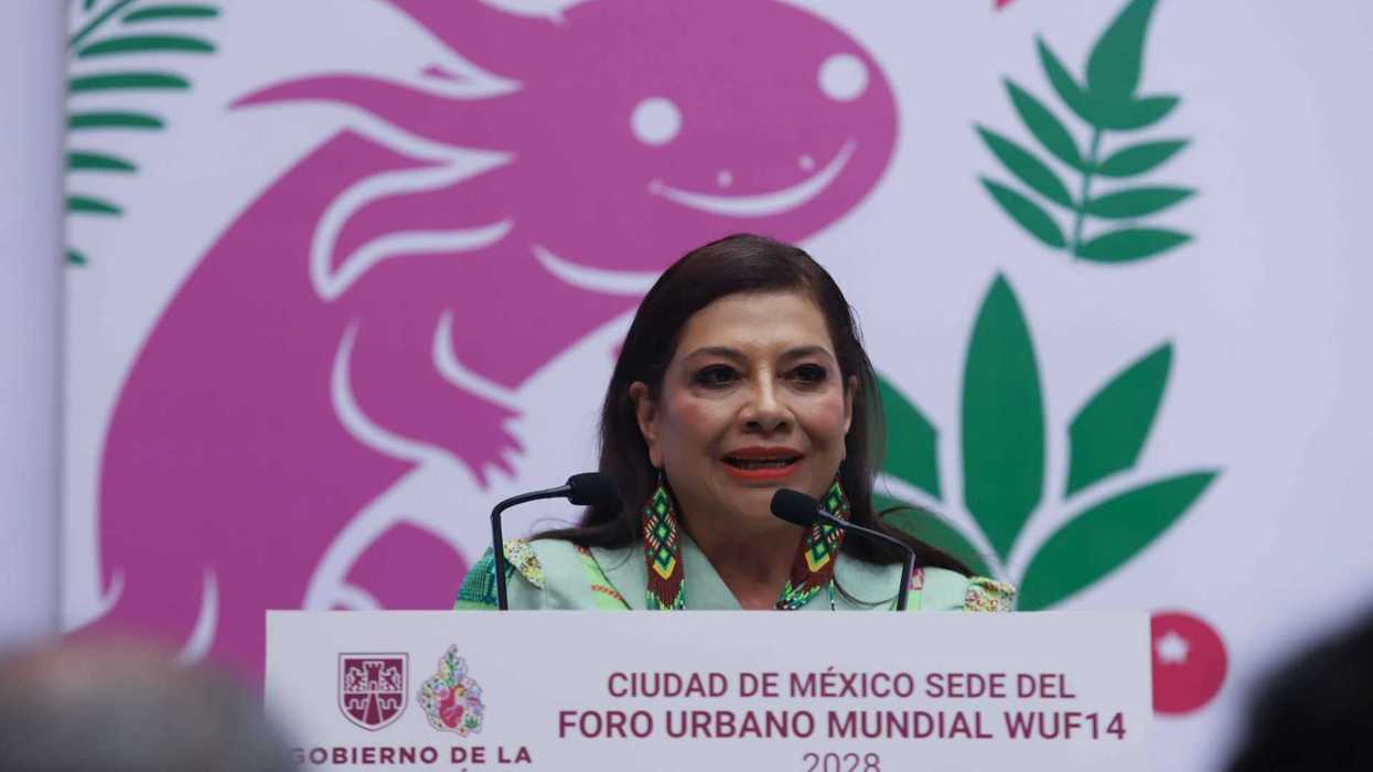 Woman speaks at podium, pink axolotl background, Mexico City 2028 WUF14 banner.