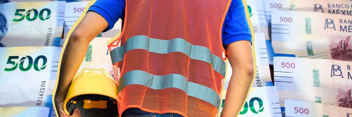 Worker in a safety vest holds a helmet against a background of Mexican 500 peso bills.